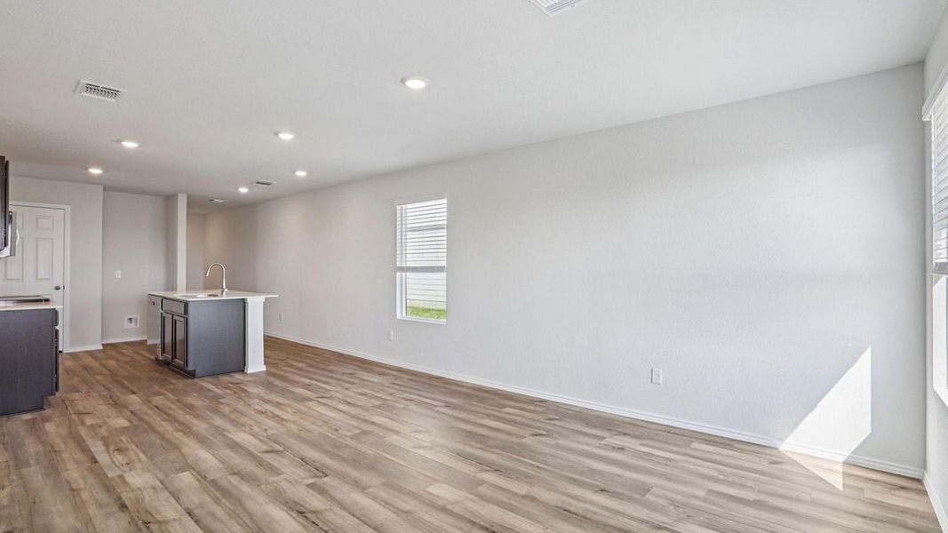 The open-concept main living area features durable wood-look flooring and recessed lighting. The open-concept main living area features durable wood-look flooring and recessed lighting.