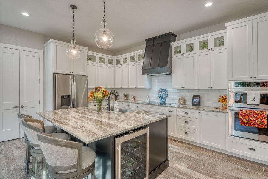 Kitchen with white cabinetry, pendant lighting, light wood-type flooring, decorative backsplash, and recessed lighting