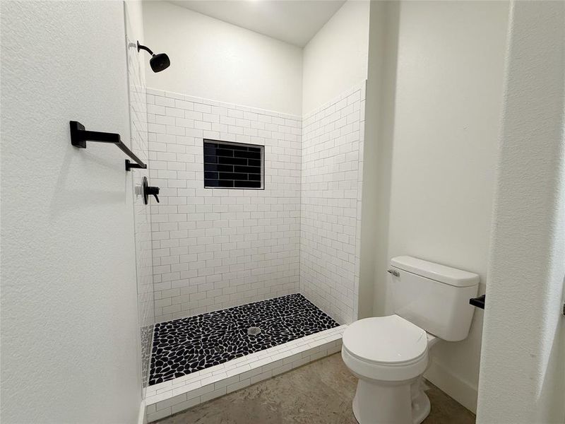 Bathroom featuring a stall shower and toilet