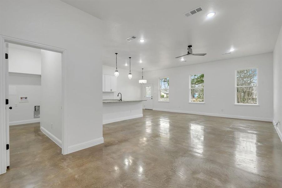 Unfurnished living room with concrete floors, a ceiling fan, and recessed lighting