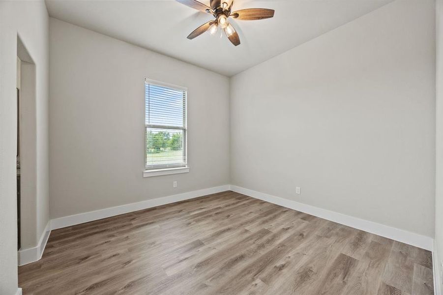 Spare room featuring light wood-type flooring and a ceiling fan Spare room featuring light wood-type flooring and a ceiling fan