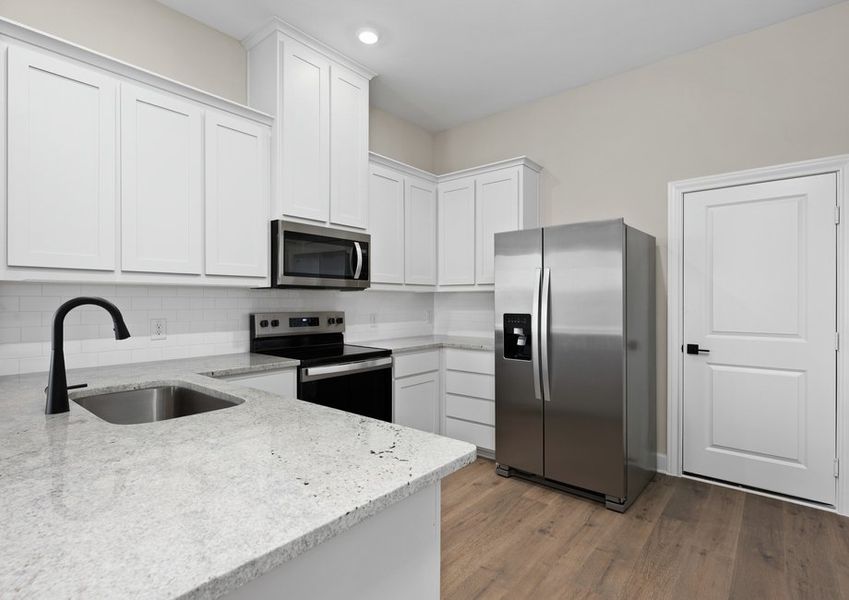 The kitchen has beautiful white wood cabinetry.