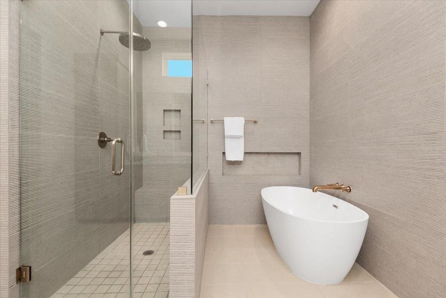 The floor-to-ceiling tile exudes luxury. Enjoy the free-standing tub with a large shampoo niche. The floor-to-ceiling tile exudes luxury. Enjoy the free-standing tub with a large shampoo niche.