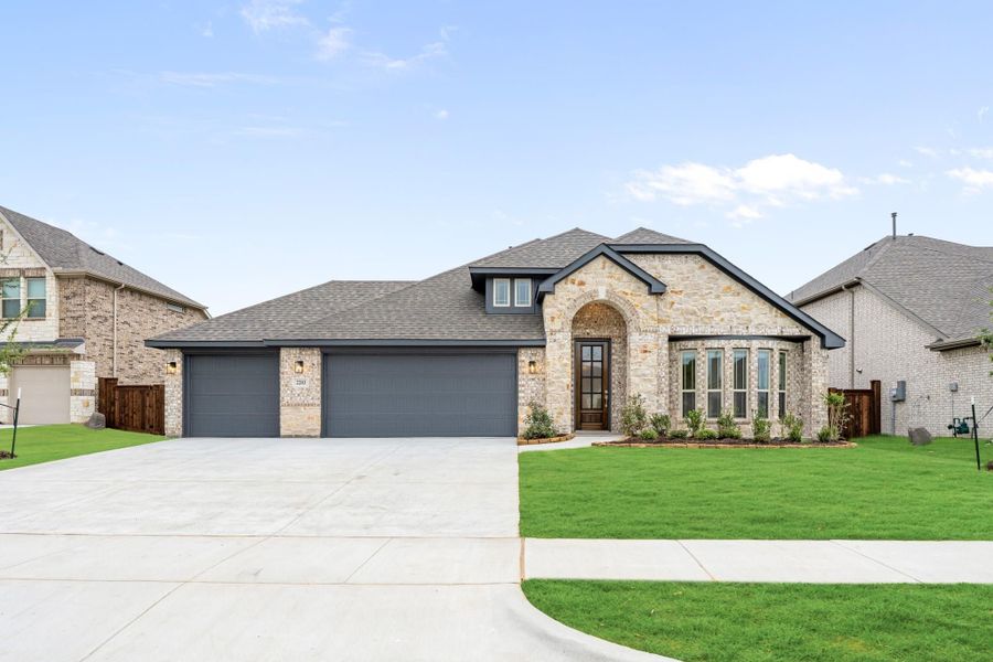 Single-story home with stone and brick exterior, three-car garage, arched entry, and green front lawn. Single-story home with stone and brick exterior, three-car garage, arched entry, and green front lawn.