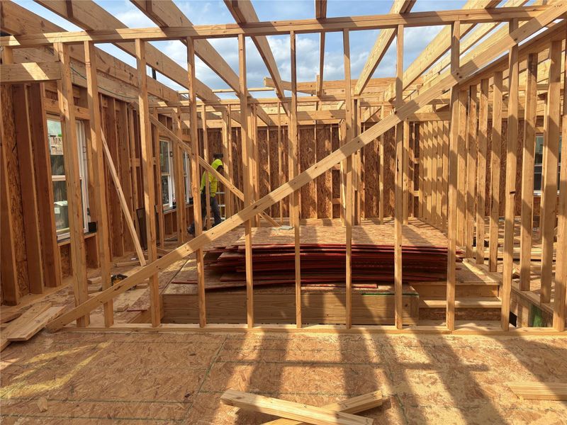 The property features a newly framed interior structure with exposed wooden beams and a subfloor, indicating new construction