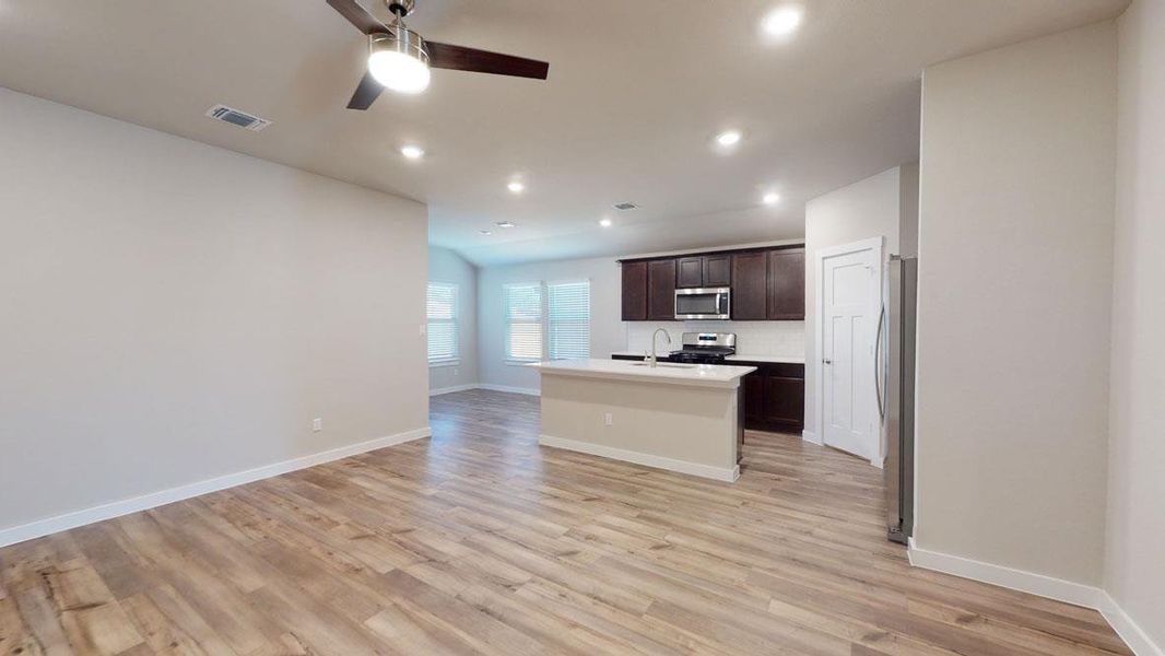 An open floorplan seamlessly connects the living area with a well-appointed kitchen, featuring a central island and contemporary finishes. An open floorplan seamlessly connects the living area with a well-appointed kitchen, featuring a central island and contemporary finishes.