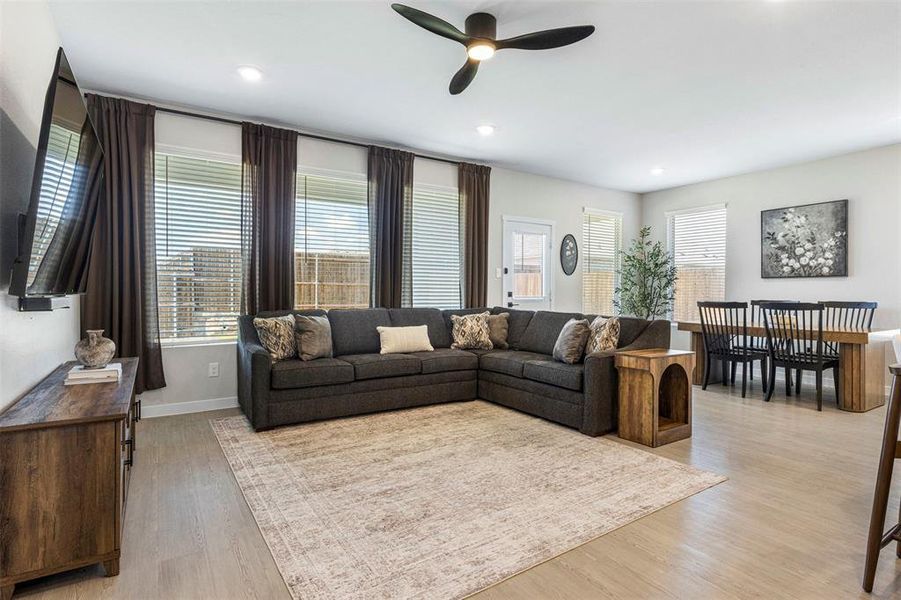 Open-concept living area with light-toned flooring and recessed lighting Open-concept living area with light-toned flooring and recessed lighting
