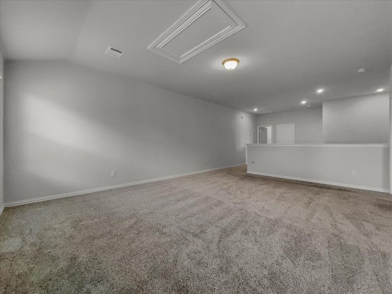 Empty room featuring vaulted ceiling and light colored carpet