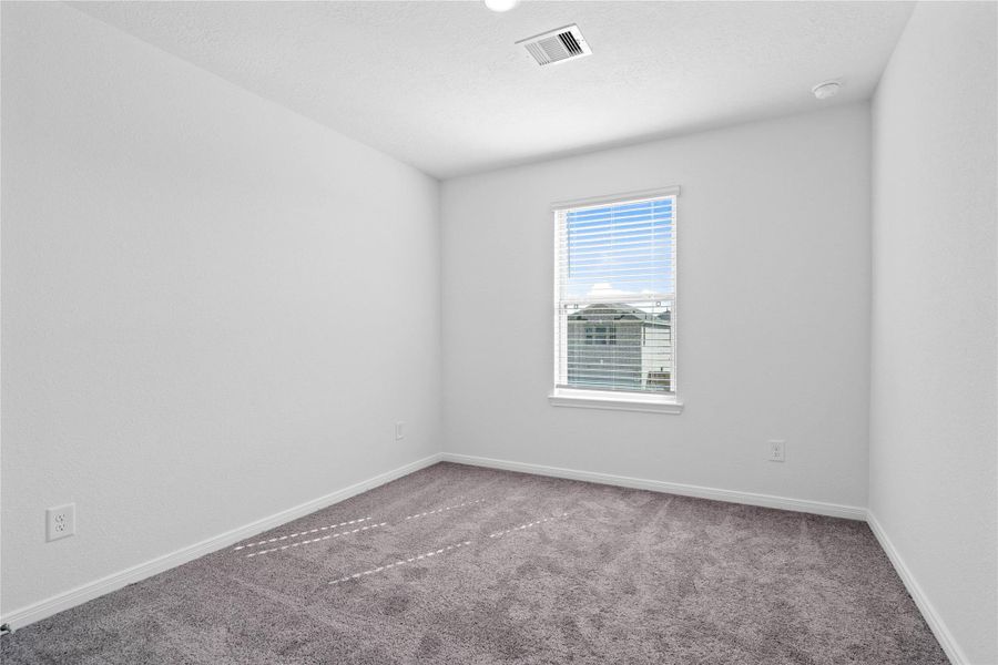 This secondary bedroom offers comfort and style with plush carpeting, neutral paint tones, recessed lighting, large window with blinds, and a generously sized closet