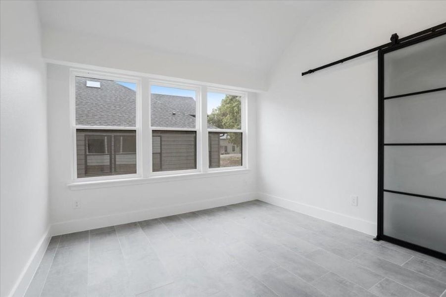 Spare room with lofted ceiling and a barn door