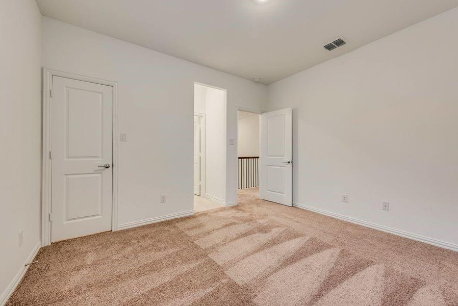 Unfurnished bedroom with light carpet