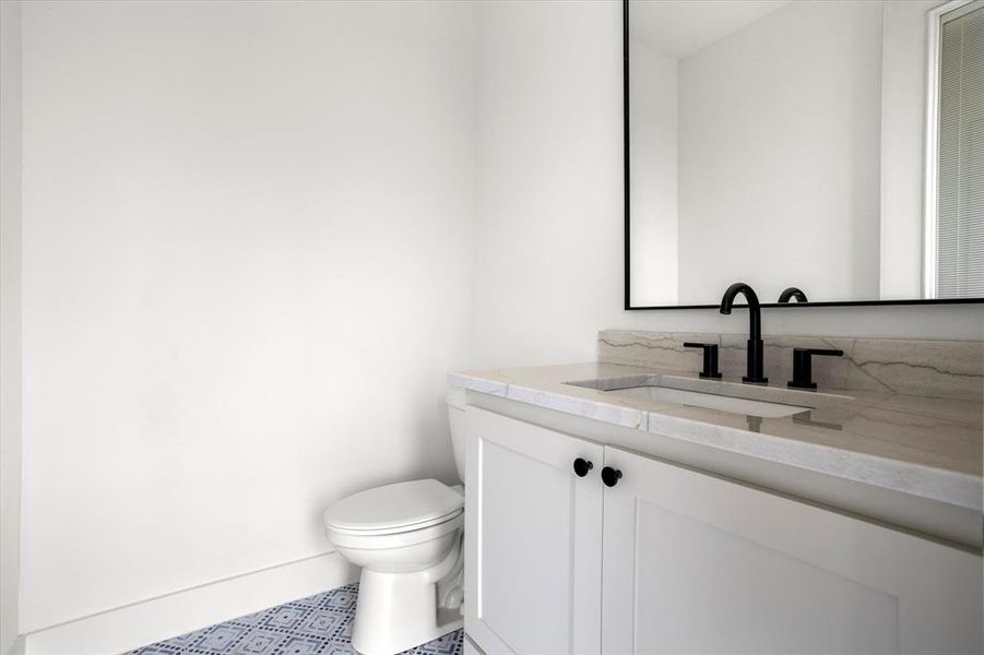 Pool bathroom with vanity and toilet located off back patio