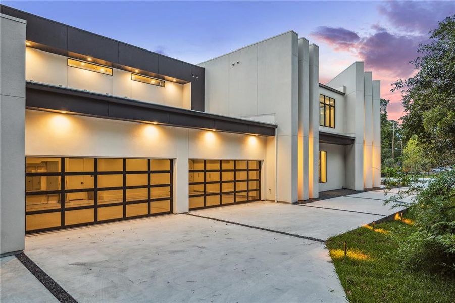 This four-car showroom garage exudes sophistication and practicality. With epoxied flooring that adds a sleek finish and durability, and spacious 12-foot ceilings accommodating even the most luxurious vehicles or personal collections, this garage becomes a haven for showcasing prized automobiles in style.