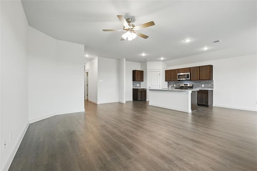 Unfurnished living room featuring a ceiling fan, recessed lighting, and dark wood-style flooring Unfurnished living room featuring a ceiling fan, recessed lighting, and dark wood-style flooring