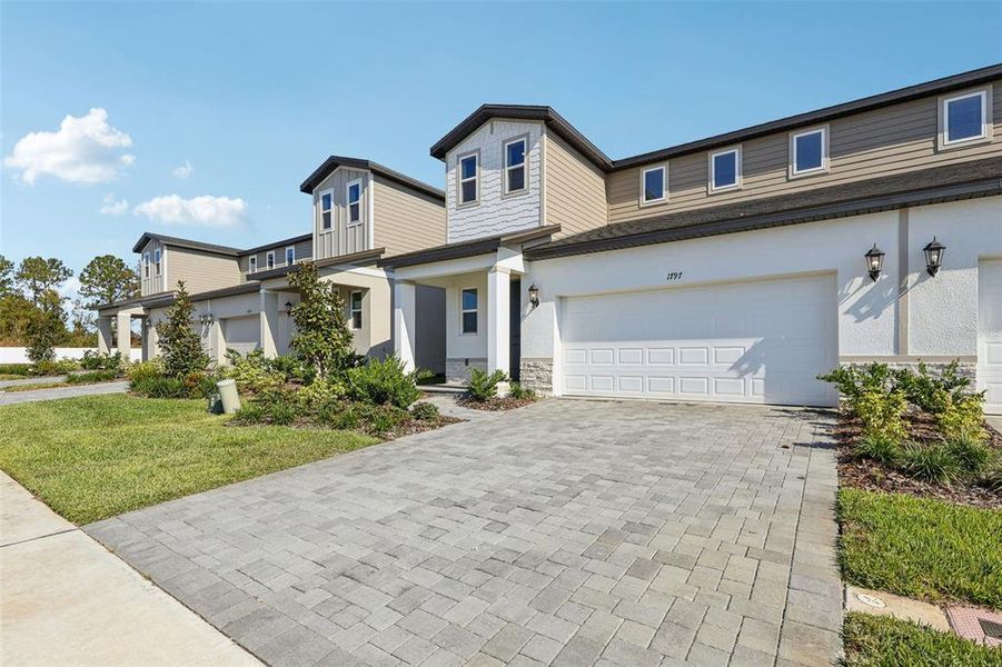 Front exterior of a new home in Cyrene at Minneola - Villas, Minneola, FL, highlighting curb appeal (Image 2).