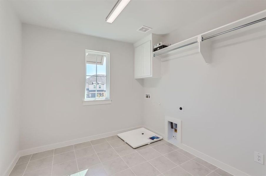 Washroom featuring hookup for a washing machine, light tile patterned floors, and hookup for an electric dryer