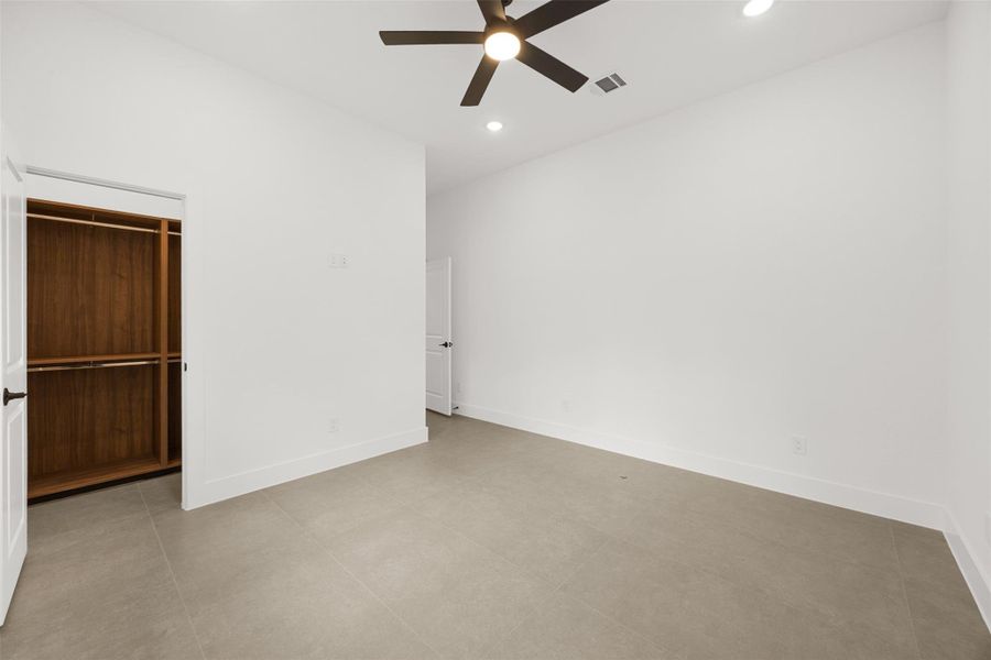 Another view of the second bedroom showing walk in closet with custom designed built-ins.