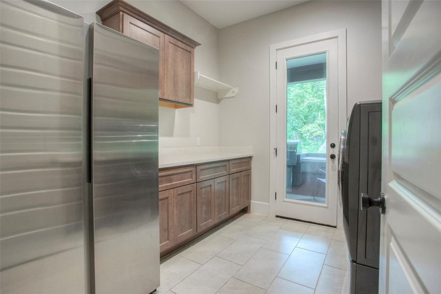 The utility room features a sink, ample counters and access to the outdoor kitchen area.