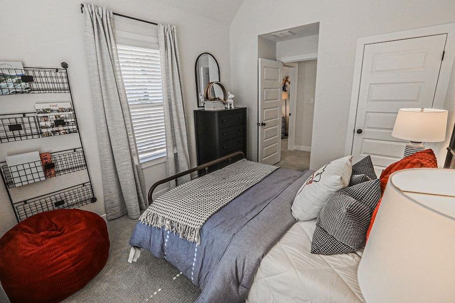 Carpeted bedroom featuring vaulted ceiling