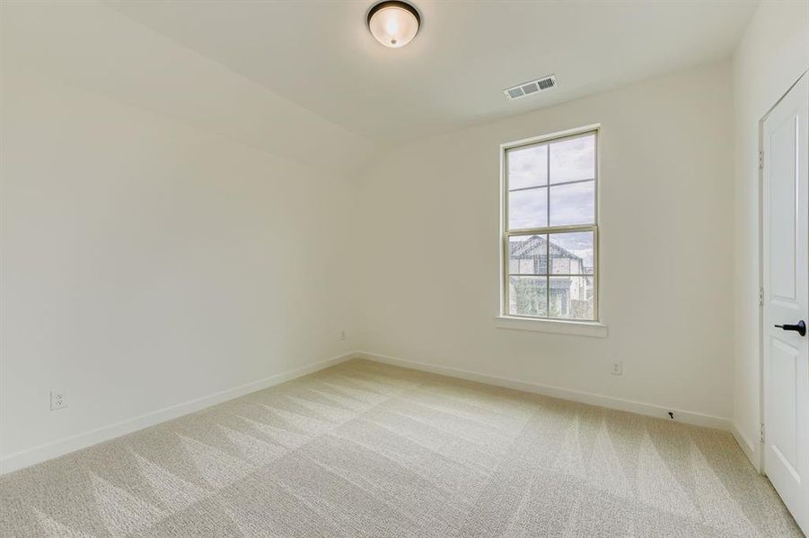 Unfurnished bedroom featuring light colored carpet and vaulted ceiling Unfurnished bedroom featuring light colored carpet and vaulted ceiling