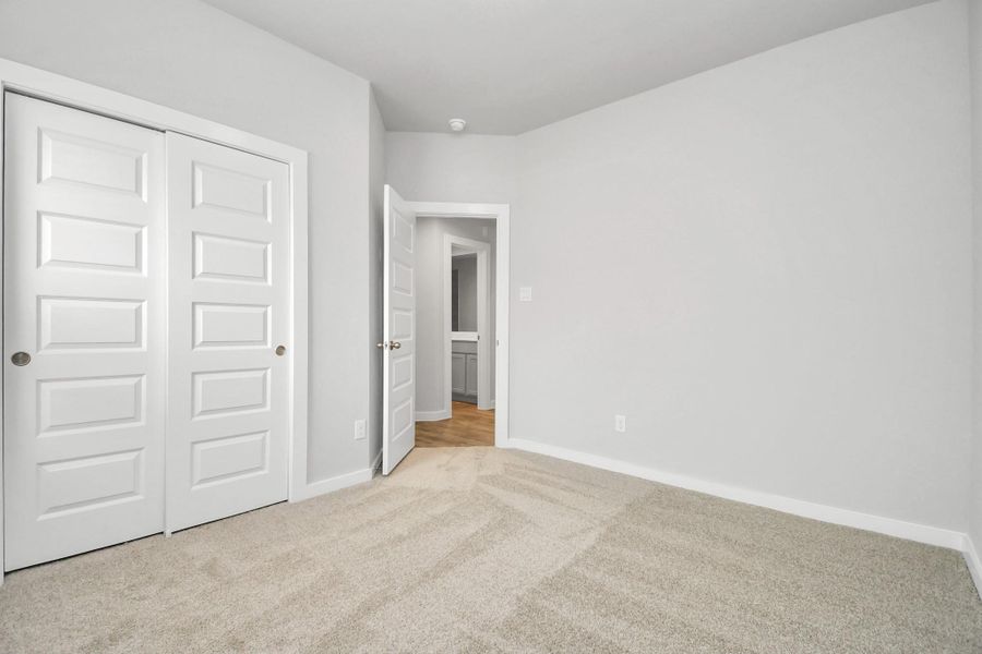 Secondary bedrooms showcase 5-panel doors adorned with modern hardware, large windows , and spacious closets featuring sleek and contemporary finishes.