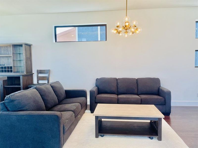 Living area with wood finished floors and a chandelier Living area with wood finished floors and a chandelier