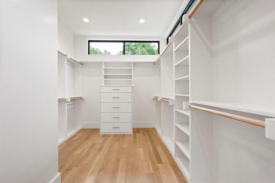 Walk in closet with light wood-style floors Walk in closet with light wood-style floors
