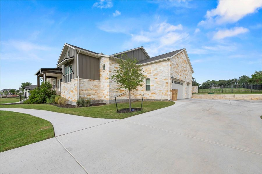 A graceful stone and siding exterior presents a harmonious blend of textures, complemented by a spacious concrete driveway leading to a multi-car garage. A graceful stone and siding exterior presents a harmonious blend of textures, complemented by a spacious concrete driveway leading to a multi-car garage.