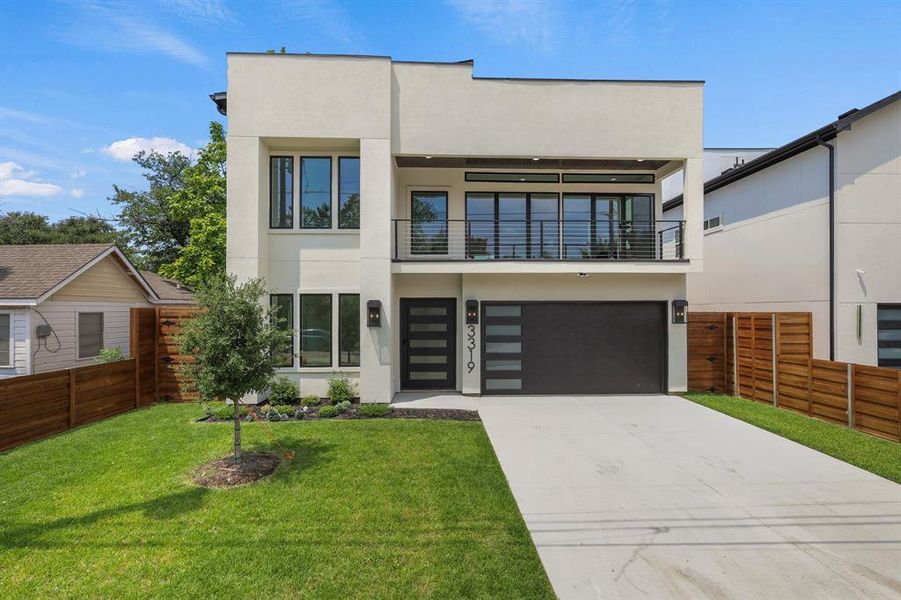 Contemporary house with a balcony, a garage, and a front yard