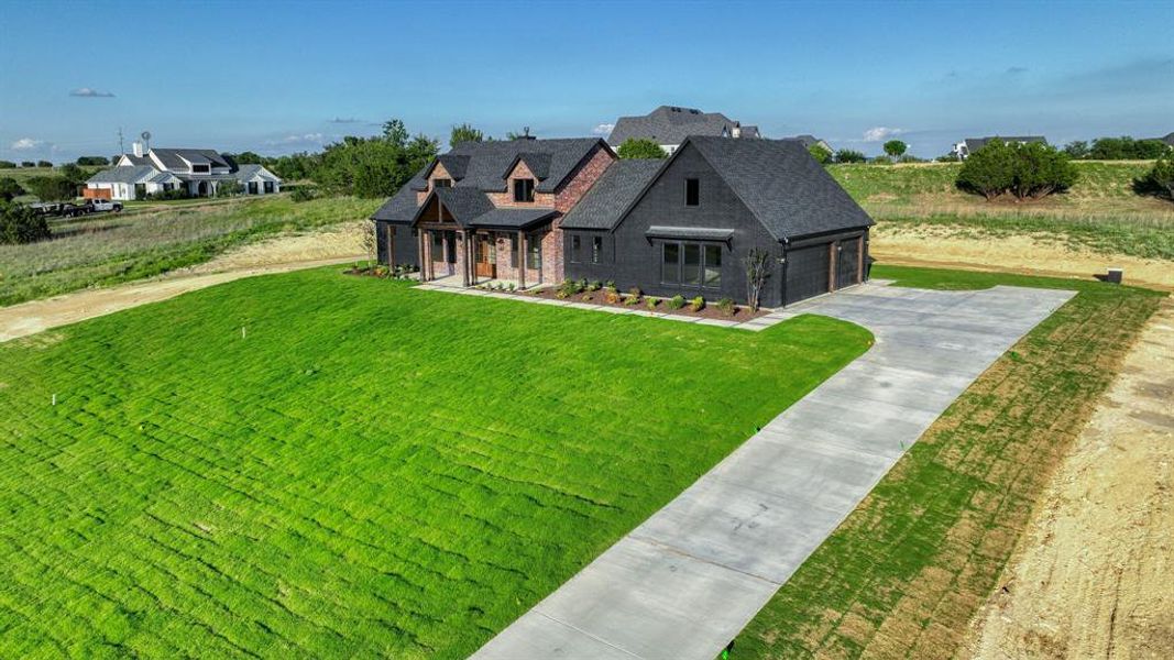 Contemporary home exterior featuring a dark facade, brick accents, and a dark shingle roof Contemporary home exterior featuring a dark facade, brick accents, and a dark shingle roof