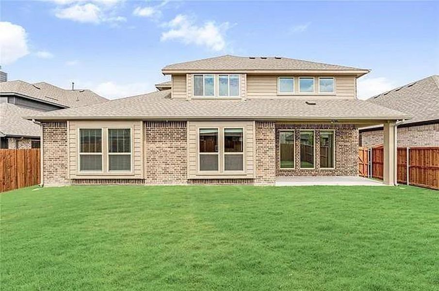 Back of property with a patio, brick siding, and roof with shingles