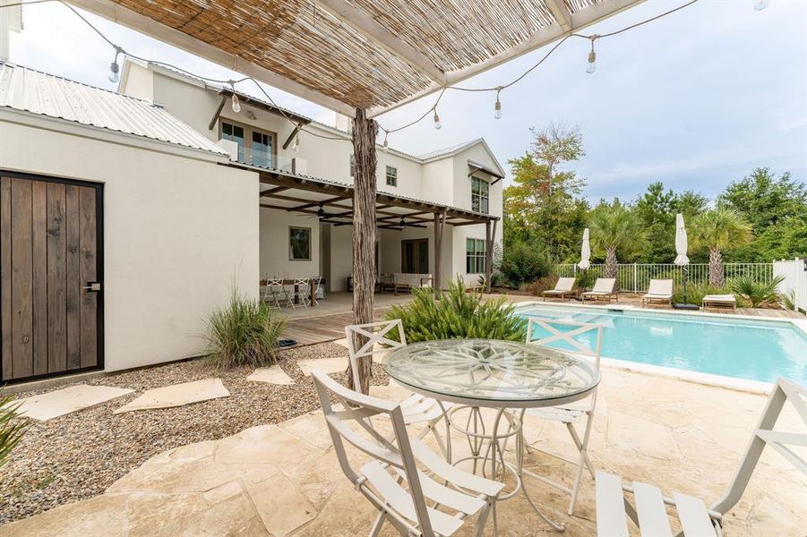 Rear view of property featuring a metal roof, a chimney, a patio area, a ceiling fan, and stucco siding Rear view of property featuring a metal roof, a chimney, a patio area, a ceiling fan, and stucco siding