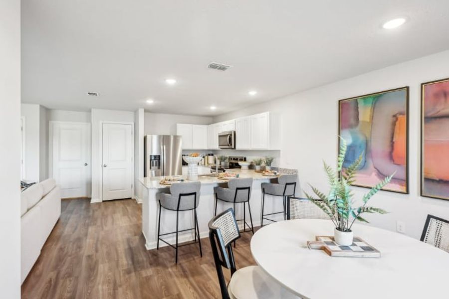 A kitchen with a dining table and chairs.