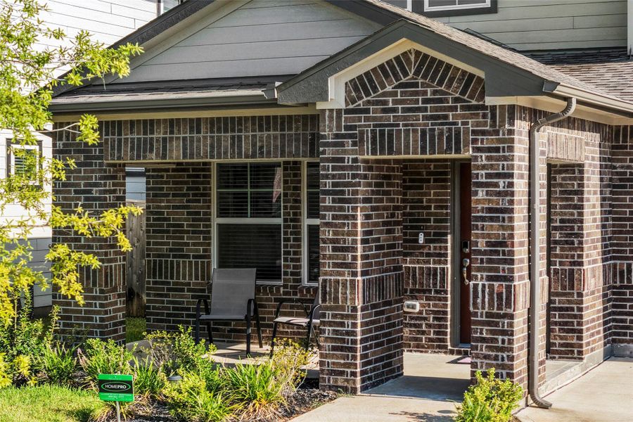 Charming brick exterior with a cozy front porch, perfect for relaxing outdoors.