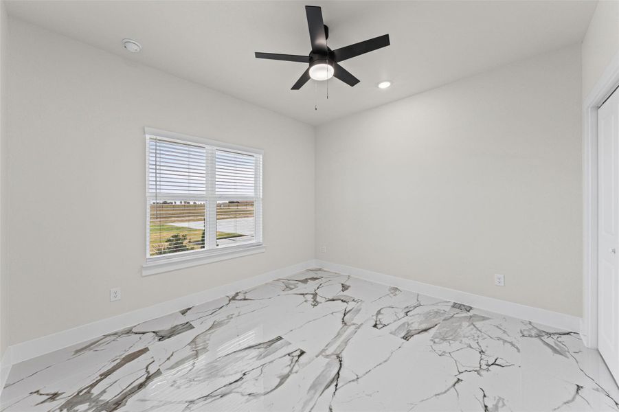 Polished stone-look tile flooring adds clean elegance to a sunlit bedroom.