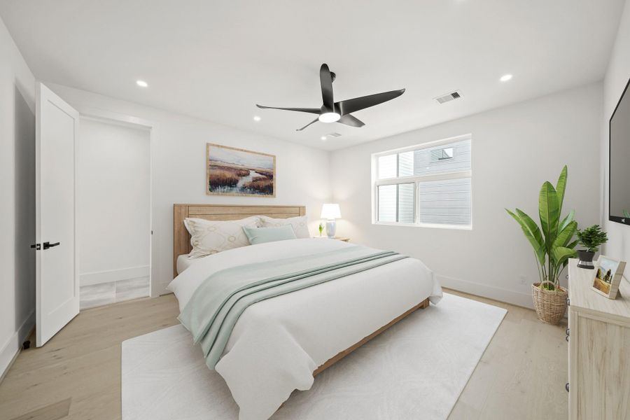 The owner's suite situated on the third level is complete with 10-foot ceilings, recessed lighting, ceiling fan, beautiful hardwood flooring, an oversized window and is pre-wired for a flat screen TV. his photo has been virtually staged.