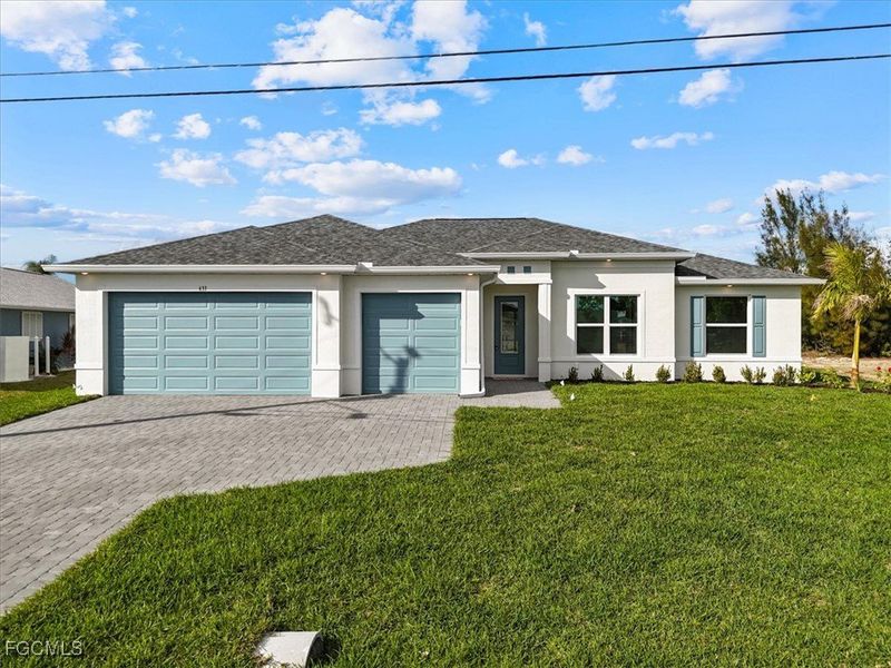 Modern-style house featuring stucco siding, a front lawn, decorative driveway, a garage, and roof with shingles