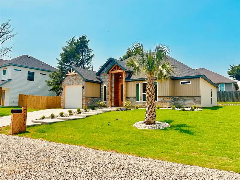 View of front of property featuring stone siding and driveway