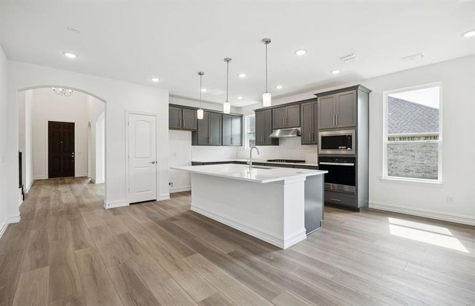 Large island overlooking gathering room and dining areas