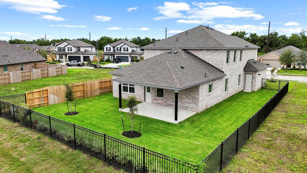 A view of the fully fenced backyard shows off the extended patio, full brick exterior, and generous green space—perfect for outdoor living with privacy and room to play. A view of the fully fenced backyard shows off the extended patio, full brick exterior, and generous green space—perfect for outdoor living with privacy and room to play.