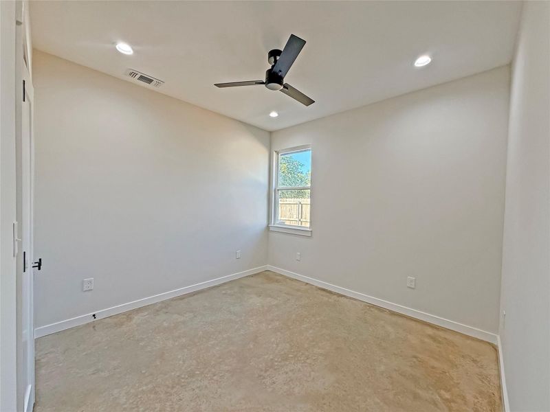 Bedroom with polished concrete flooring, recessed lighting, and ceiling fan
