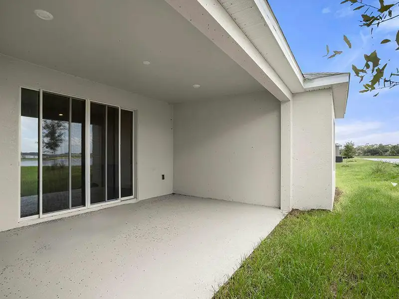 A triple sliding glass door opens to outdoor living space on your covered lanai - Everly by Highland Homes