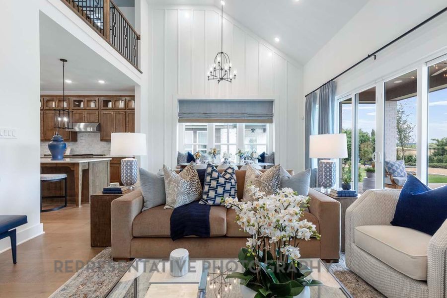 Living area with a chandelier, high vaulted ceiling, recessed lighting, and light wood-type flooring