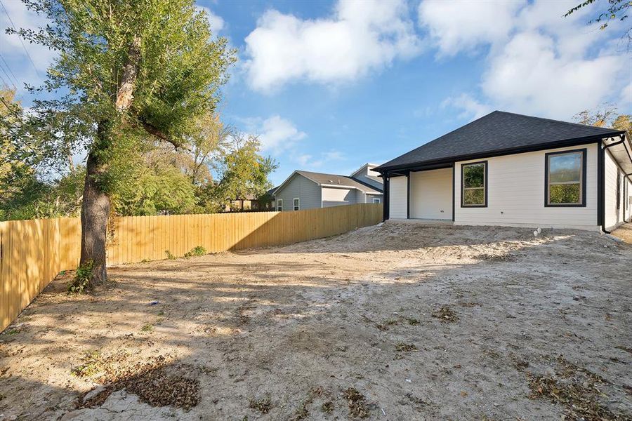 Rear view of house featuring roof with shingles and a patio area