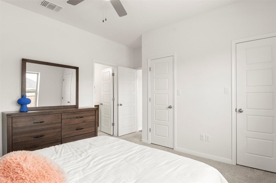 Carpeted bedroom featuring baseboards and ceiling fan