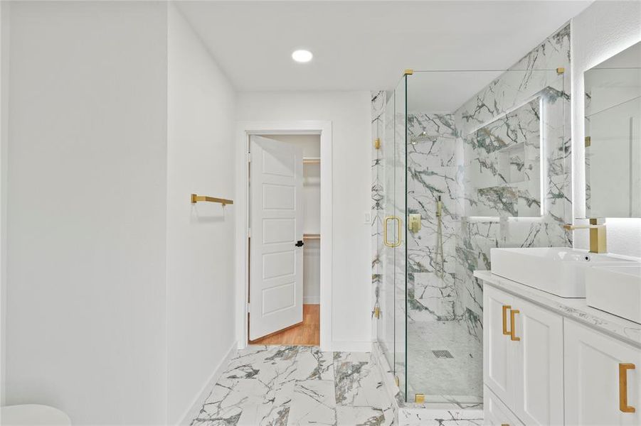 Bathroom featuring vanity and a shower with door