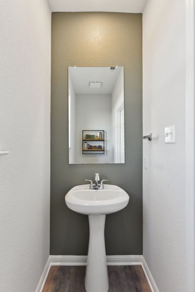 A bathroom with a mirror and sink. A bathroom with a mirror and sink.