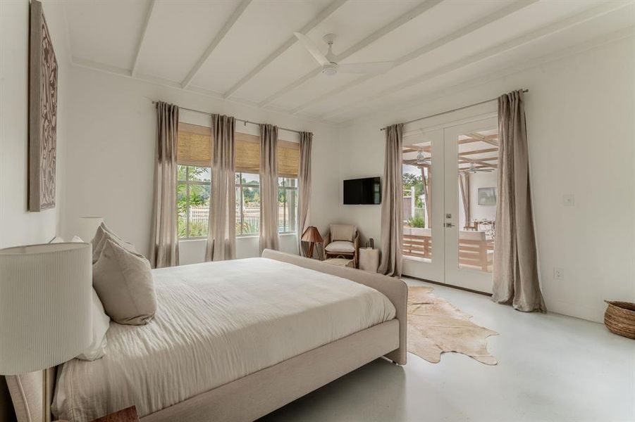 Living area featuring a wood ceiling with exposed beams, a ceiling fan, finished concrete flooring, and stairs Living area featuring a wood ceiling with exposed beams, a ceiling fan, finished concrete flooring, and stairs