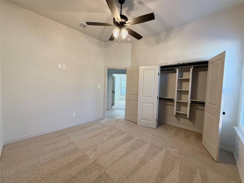 Unfurnished bedroom with light colored carpet, a closet, and ceiling fan