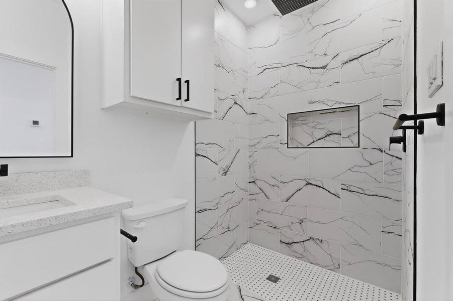 Bathroom with a marble finish shower and vanity